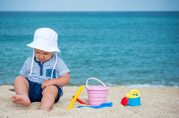 Fototapeta na wymiar Cute baby boy playing with beach toys