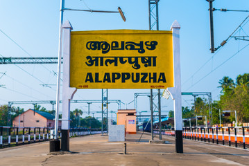 Railroad sign "Alappuzha" (Alleppey) written in Malayalam (official language of Kerala), Hindi and English on a platform of the Alappuzha (Alleppey) railway station, Kerala, India