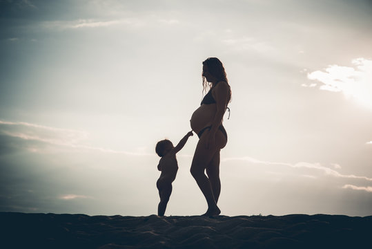 Silhouette pregnant woman and her son