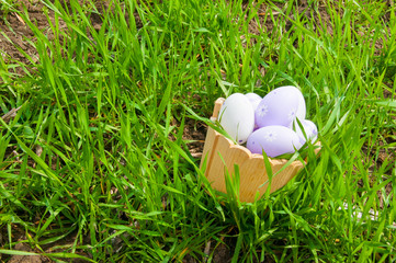 Fototapeta na wymiar Colorful Easter eggs in a basket in the grass