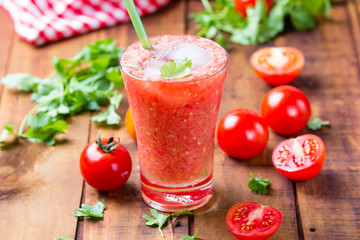 Tomato smoothie on wooden background