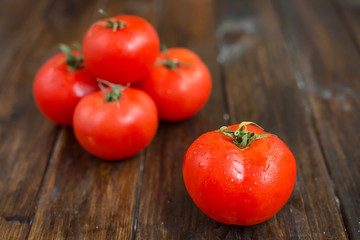 juicy and beautiful tomatoes on wooden rustic background