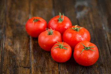 juicy and beautiful tomatoes on wooden rustic background