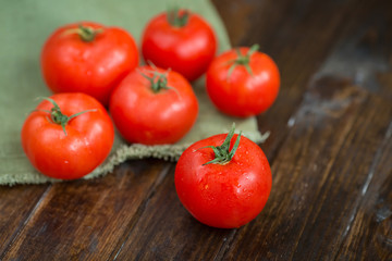 juicy and beautiful tomatoes on wooden rustic background
