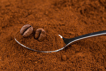 ground coffee and a metal spoon