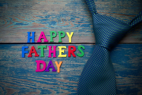 Happy fathers day sign and tie laid on wood 