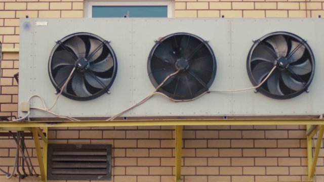 Industrial air conditioning sustem on the wall outdoors. Rotating fans conditioner of an industrial building