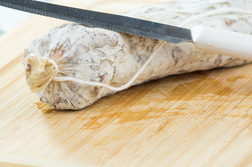 salame, salumi su tagliere con coltello, salame affettao, salame cacciatore, cacciatorino