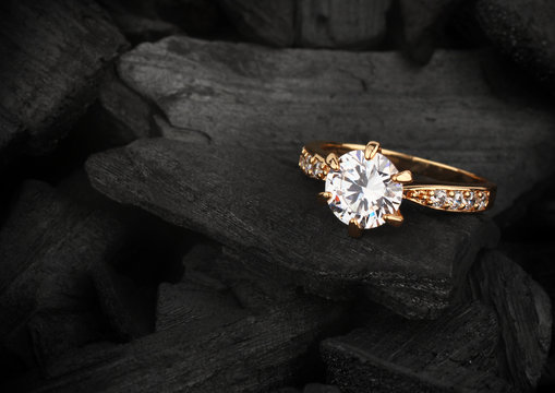 jewelry ring witht big diamond on dark coal background, soft foc