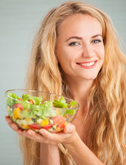 Young woman preparing vegetable salad