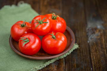 juicy and beautiful tomatoes on wooden rustic background