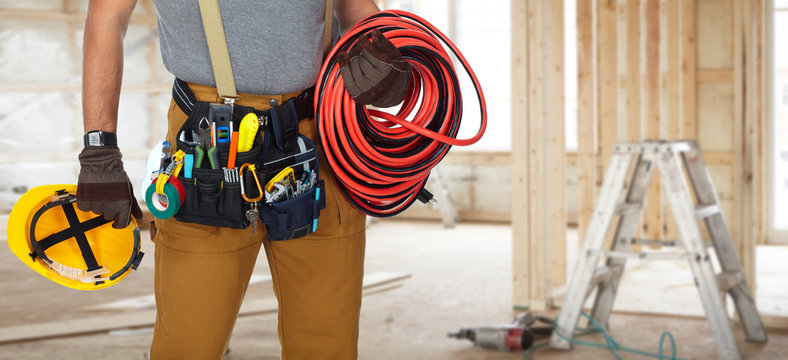 Electrician with construction tools and cable.
