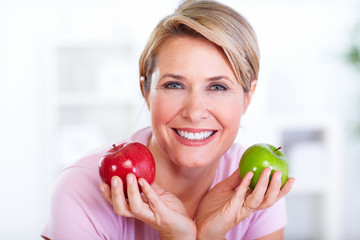 Mature smiling woman with apple.