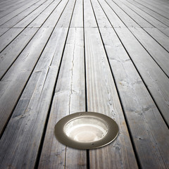 Recessed floor lamp on wooden floor - image with copy space