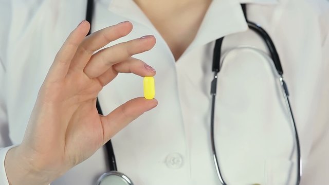 Hospital physician offering patient a pill, medical prescription for treatment
