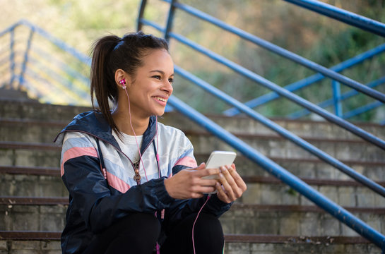 Beautiful hispanic woman listen music after running