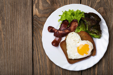 Scrambled eggs with heart shaped sausage and space for text