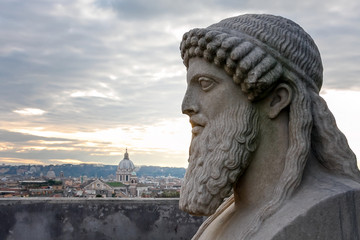 Carved marble bust of an ancient king, in the background the panorama of the city of Rome.