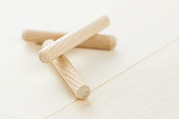 Close up heap of wooden dowel pins on wooden background
