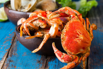 Seafood. Bowl of crabs and soup of slams on wooden blue background. Traditional food on Holy week Easter in Latin America. 