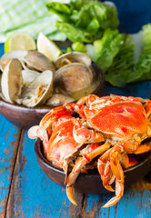 Seafood. Bowl of crabs and soup of slams on wooden blue background. Traditional food on Holy week Easter in Latin America. 