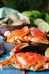 Seafood. Bowl of crabs and soup of slams on wooden blue background. Traditional food on Holy week Easter in Latin America. 