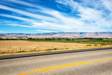 Fototapeta na wymiar Highway passing through fields in Shell, Wyoming