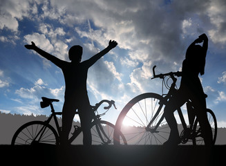 Fototapeta premium Two cyclists on a bicycle in the sunset