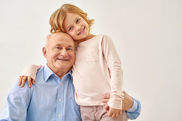 Little granddaughter hugging her grandfather