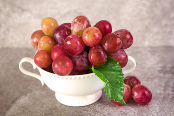 still life with red grapes in white  vintage cup , selective foc