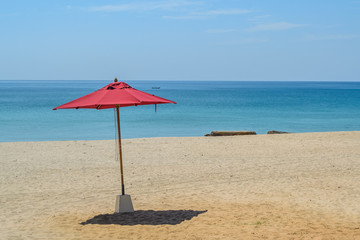 red umbrella on the beach with blue sky background