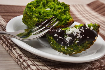 Fresh muffins with spinach, desiccated coconut and chocolate glaze, delicious healthy dessert