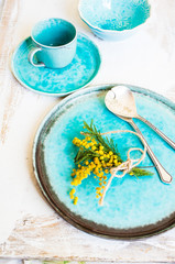Table setting with sprig mimosa flowers