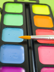 Акварельные яркие краски с кисточкой крупным планом