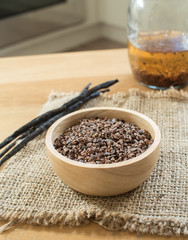 Bowl of Cacao nibs and vanilla bean on on sackcloth