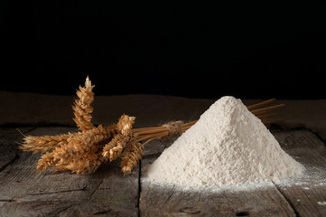 handful of wheat flour closeup with wheat ears