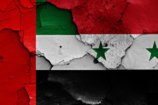 flags of United Arab Emirates and Syria painted on cracked wall