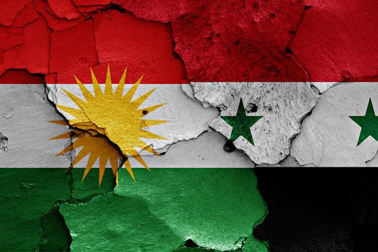 flags of Iraqi Kurdistan and Syria painted on cracked wall