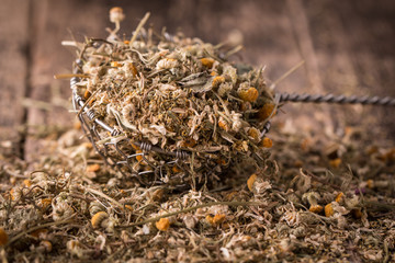dried chamomile flowers, herbal tea raw  on wooden table