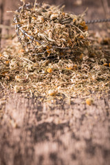 dried chamomile flowers, herbal tea raw  on wooden table