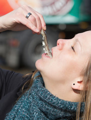 Obraz na płótnie Canvas Dutch woman is eating typical raw herring