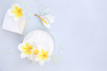 Top view of organic cream and soap bar with frangipani flower