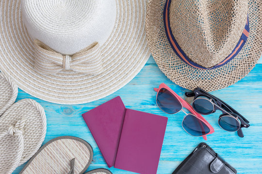Summer hats  and other travel accessories on blue wooden backgro