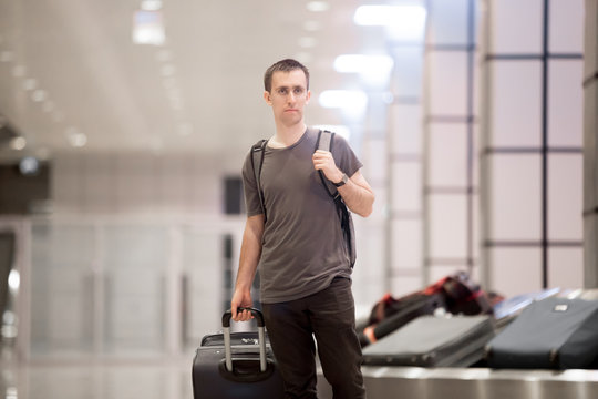 Traveller with luggage at conveyor belt