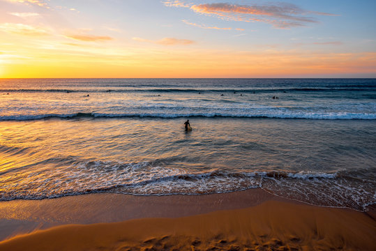 Beautiful beach with surfers swimming near El Cotillo village on Fuerteventura island in Spain