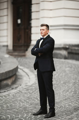 Sexy man, groom posing in old city