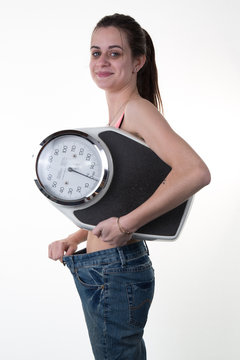 Portrait of a weight loss female holding a weight scale isolated on white background
