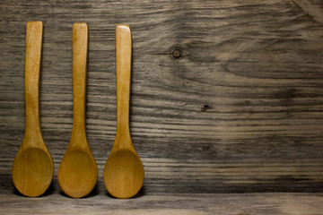Wooden kitchen spoon on wooden background. Space for text.