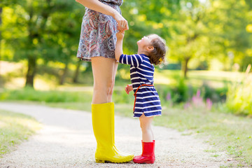 mother and little girl in rubber boots having fun 