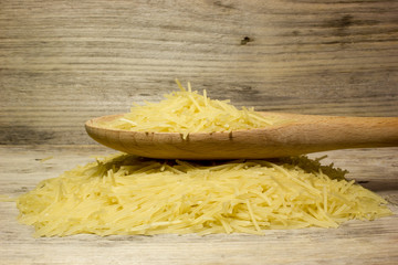 Small dry pasta noodles on wooden background